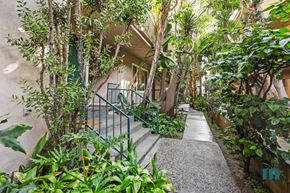 Los Angeles apartment for rent - A pathway with a metal railing on the left side and a building in the background.