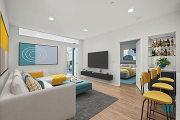 Los Angeles apartment for rent - A modern living room with a white sofa, a grey rug, a yellow chair and a painting on the wall.