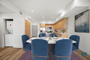 Los Angeles apartment for rent - a long dining table with blue chairs in a room with white walls and wooden floors
