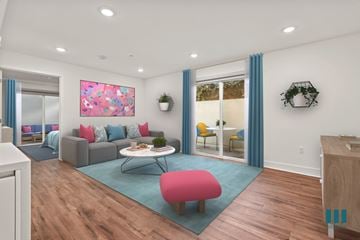 Los Angeles apartment for rent - A living room with a grey couch, a pink ottoman, a coffee table, and a painting on the wall.