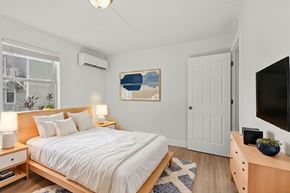 New Smyrna Beach apartment for rent - A bedroom with a bed, nightstands, and a painting on the wall.