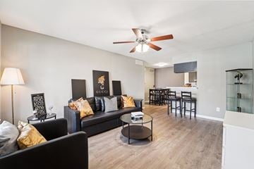Houston townhouse for rent - A living room with a black couch and a ceiling fan.