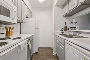 Houston apartment for rent - A kitchen with white appliances and a white counter top.