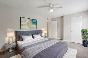 Houston apartment for rent - A bedroom with a large bed and a ceiling fan.