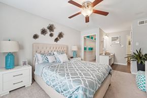 Houston apartment for rent - A bedroom with a large bed and a ceiling fan.