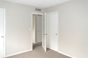 Daytona Beach apartment for rent - A bedroom with a carpeted floor and three doors.