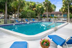 South Daytona apartment for rent - One of Ridge Apartments two sparkling swimming pools with a sundeck and lounge chairs