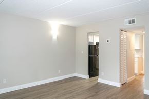 South Daytona apartment for rent - a living room with a wall sconce and an entrance to a hall and kitchen