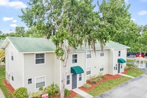 New Smyrna Beach apartment for rent - the well-kept exterior of a residential building at Haven on Canal surrounded by trees