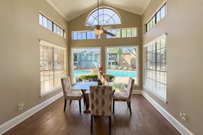 Houston apartment for rent - a dining area surrounded by windows overlooking the pool at Waters at Westchase