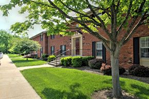 Elkhart apartment for rent - exterior view of a brick apartment building with a sidewalk and trees