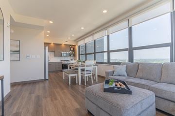 South Bend apartment for rent - A modern living room with a grey couch and a wooden floor.