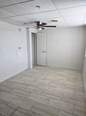Logansport apartment for rent - A room with a ceiling fan and a door.
