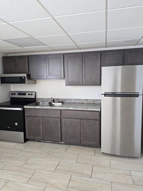 Logansport apartment for rent - A kitchen with a white fridge and black oven.