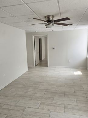 Logansport apartment for rent - A room with a ceiling fan and tile flooring.
