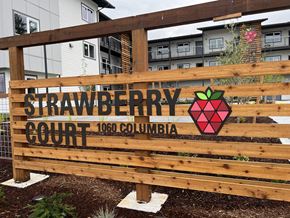 Marysville apartment for rent - A wooden sign that says Strawberry Court in front of a building.