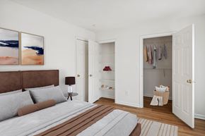 Chester apartment for rent - A bedroom with a bed, a nightstand with a lamp, a wardrobe with clothes hanging and a painting on the wall.