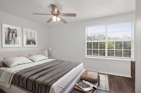 Weatherford apartment for rent - A bedroom with a bed, a ceiling fan, and two framed pictures on the wall.