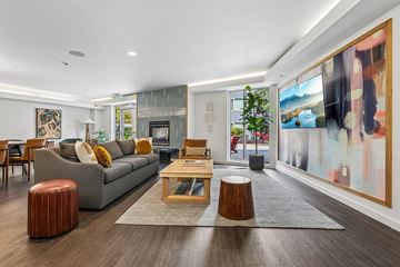 Redmond apartment for rent - A modern living room with a grey sofa, wooden coffee table, and a large abstract painting on the wall.