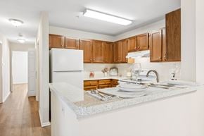 Woodbridge apartment for rent - A kitchen with wooden cabinets and a white countertop.