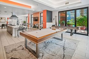 Northridge apartment for rent - A billiard table is in the middle of a room with a kitchen area.