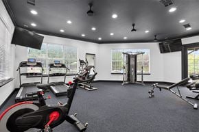 Weatherford apartment for rent - A spacious gym with a variety of exercise equipment including treadmills, stationary bikes, and weight machines.
