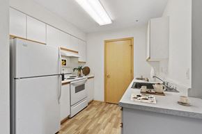 Lakewood apartment for rent - Kitchen with a white refrigerator freezer next to a stove top oven at Lakewood Meadows Apartments in Lakewood WA