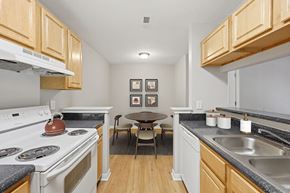 Durham apartment for rent - Kitchen with light wood cabinets at Greens of Pine Glen in Durham NC
