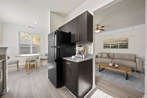 Chester apartment for rent - A black refrigerator is in the middle of a kitchen with a table and chairs.