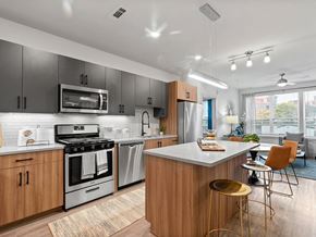 Chelsea apartment for rent - Kitchen island with seating and view of living area at VERO in Chelsea MA