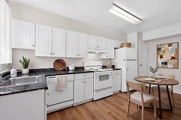 Silver Spring apartment for rent - A kitchen with white cabinets and a black countertop.