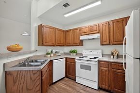 Weatherford apartment for rent - A kitchen with wooden cabinets and white appliances.