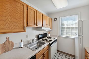 Arlington apartment for rent - A kitchen with wooden cabinets and a white fridge.