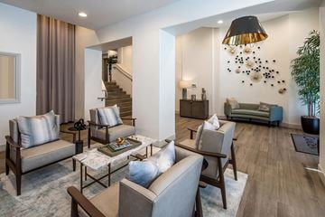 San Diego apartment for rent - A living room with a staircase in the background and a couch with a pillow on it.