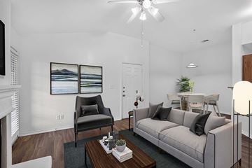 Weatherford apartment for rent - A living room with a grey couch, a black chair, a coffee table, and a painting on the wall.