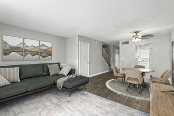 Nashville apartment for rent - A living room with a grey couch and a painting of mountains on the wall.