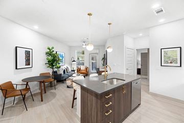 Houston apartment for rent - a kitchen with an island and a living room with a table and chairs