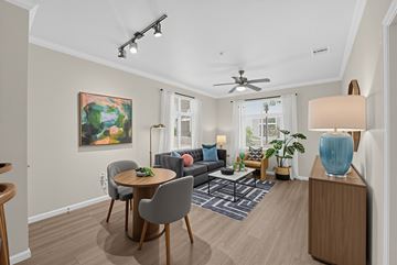 San Jose apartment for rent - A living room with a grey couch, a round table, and a painting on the wall.