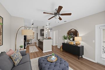 San Jose apartment for rent - A living room with a grey couch and a round ottoman.