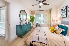 San Diego apartment for rent - Sepia Design Package Bedroom with ceiling fan and large window at The Seaton Apartments in San Diego CA
