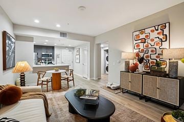 Pasadena apartment for rent - A modern living room with a black coffee table and a large abstract painting on the wall.