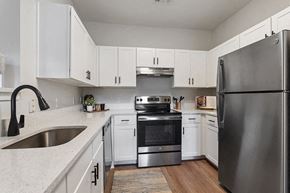 Lawrence apartment for rent - a kitchen with stainless steel appliances and white cabinets