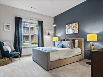 Andover apartment for rent - A bedroom with a large bed and a chair by the window.