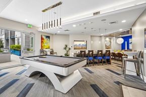 Tempe apartment for rent - A pool table is in the middle of a room with a blue carpet.