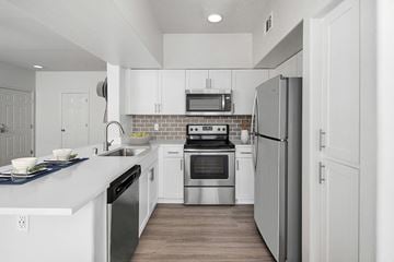 Murrieta apartment for rent - A modern kitchen with white cabinets and stainless steel appliances.