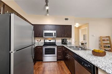 Mission Viejo apartment for rent - A modern kitchen with dark wood cabinets and stainless steel appliances.