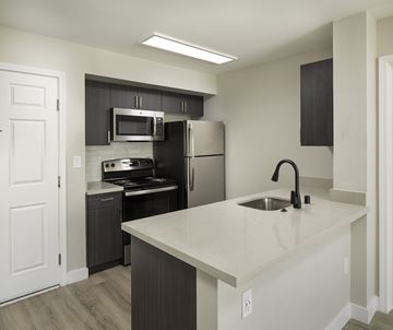 San Diego apartment for rent - A kitchen with a white countertop and black cabinets.