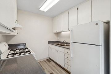 San Diego apartment for rent - A kitchen with white cabinets and a white fridge.