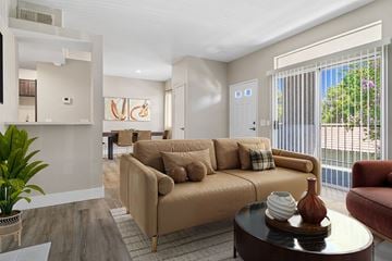 Corona apartment for rent - A living room with a tan couch and a coffee table.
