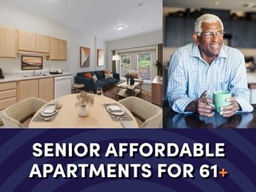 Seattle apartment for rent - a man sitting at a table with a mug in a living room and a kitchen